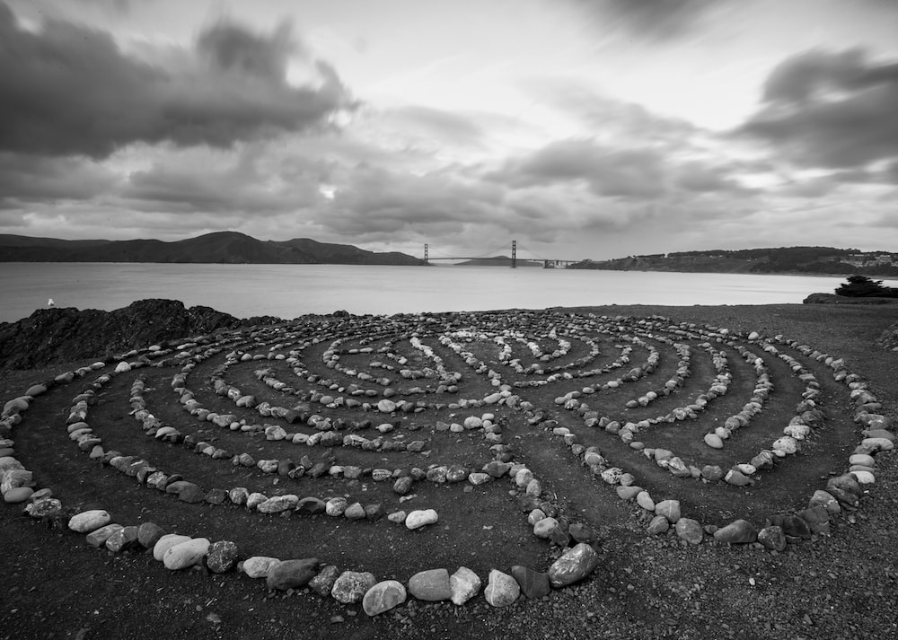 Lands End Labyrinth in grayscale with the Golden Gate Bridge in the distance behind it. 