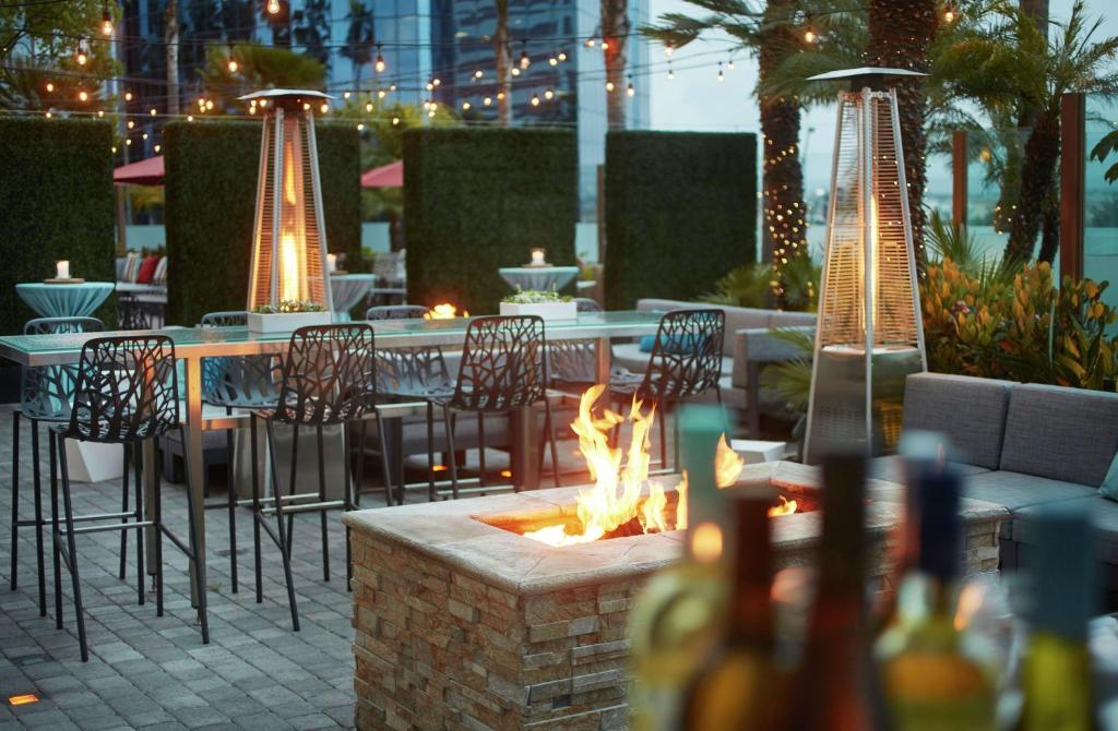 otudoor bar at Embassy Suites by Hilton San Diego La Jolla with bar chairs and table surrounded by fireplace