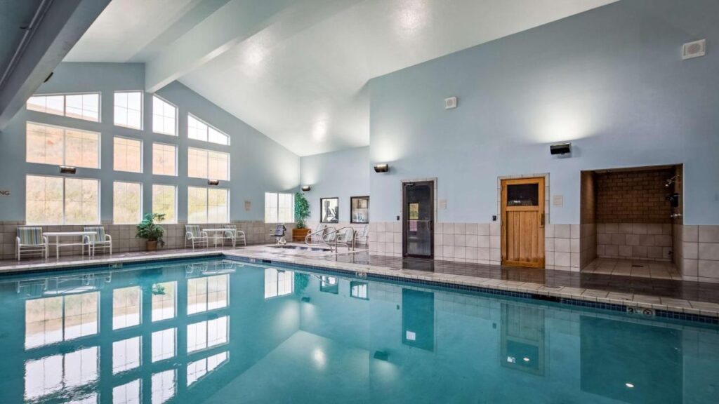 indoor pool at Best Western Plus Grant Creek Inn a dog friendly hotel in Missoula with huge windows that provides natural light. there are lounge chairs and a small jacuzzi at the corner