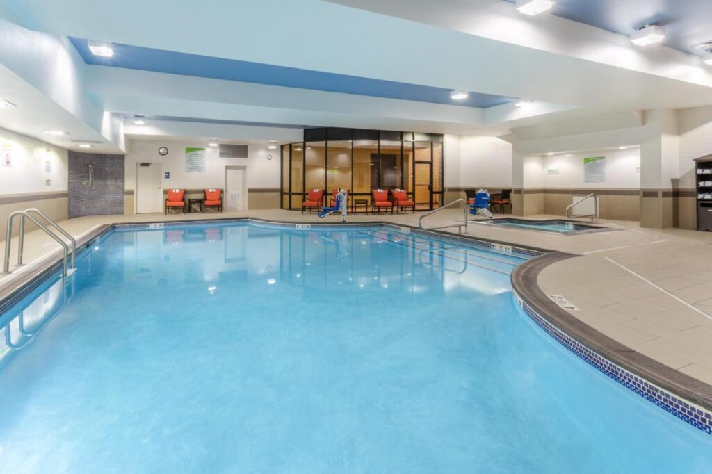 large indoor pool with a smaller pool on the beside. there are orange chairs on the side at Holiday Inn Missoula Downtown a pet friendly hotel in Missoula